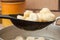 A sieve with ready dumplings above the pan with dumplings with a blurred background ready to eat