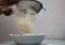 Sieving flour on a bowl