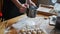 Sifting flour through sieve. Women hands sifting flour on a table. Cooking and backing preparation.