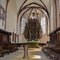 Sighisoara, Romania - July 2, 2019: Interior of the Church of the Dominican Monastery in Sighisoara. The bronze baptismal font