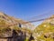 Sights of Montenegro. Landmark Old rusty bridge. Attraction Long extreme suspension iron bridge across the river Moraca