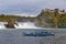 Sightseeing boat taking tourists to the Rhine Falls, famous and biggest waterfall in Europe on the Rhine River in Switzerland