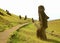 Sightseeing path among large group of abandoned giant Moai statues on the slope of Rano Raraku Volcano, Easter Island, Chile