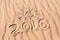 Sign 2016 and sun written on sandy beach. Summer travel concept