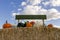 Sign above a bunch of pumpkins sitting on a hay bale.