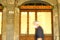 Sign of the ancient Palazzo Orlandi in Busseto. A man with a mask passes in motion in front of the shutter of the shop