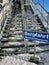 Sign Ascent (Bergfahrt) in front of iron stairs at ski lift in Austrian Alps. Vertical.