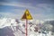 Sign on background of mountains. Sign warning of danger of falling. Triangle on stick. Symbol on yellow background. Carefully