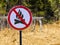 Sign ban bonfires on the background of forest and dry grass and trees.