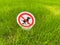 Sign banning dog excrement on a green grass meadow