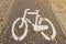 The sign is a bicycle path sprinkled with autumn fallen leaves. Road markings on the pavement of the sidewalk to separate the