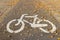 The sign is a bicycle path sprinkled with autumn fallen leaves. Road markings on the pavement of the sidewalk to separate the move