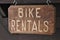 Sign `bike rentals` on a wooden plate