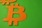 The sign of bitcoin is orange on a green background in the style of minimalism. Collage concept cryptocurrency