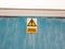 A sign on blue wall saying warning anti climb paint