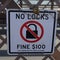 Sign on the Brooklyn Bridge warning people of a $100 fine if you place a lock on the bridge