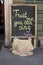 Sign on the chalkboard on the cafe `Thrust me you can sing`