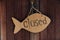 Sign is closed in the form of fish from cardboard. Hanging on the door on the rope