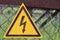 A sign of danger. Dark brown lightning against the yellow triangle