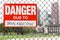 Sign danger due to drug addiction hanging on the fence