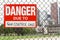 Sign danger due to gun control laws hanging on the fence