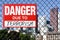 Sign danger due to terrorism hanging on the fence