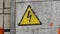 Sign of danger electric shock rotate. Yellow designation of high voltage on door