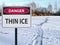 Sign danger thin ice and footprints road on snow and ice