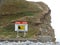 A sign depicting dangerous cliffs on a pebble beach in the UK