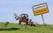 Sign with farmer protest Germany with a tractor mowing hay