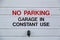 a sign on the front of a private garage reading No parking garage in constant use