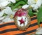 The sign of `Guards` on the background of the blooming Apple tree and of the St. George`s ribbon. Heirloom. Memory. May 9