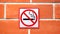 Sign hangs on a brick wall warning that smoking is not permitted in the area