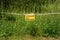 Sign with the inscription on german caution Electric fence hangs on an electric fence in front of a green meadow