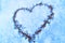 Sign of love-heart painted on snow, pastel blue background, Valentine's day