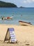 Sign offering boat tours to beaches nearby at Praia do Sono, popular beach in Paraty, Rio de Janeiro