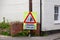 A sign on a post when entering a village stating there is a skid risk for the next 100 yards