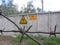 Sign  radiation on the grey fence of the restricted area with barbed wire