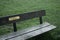 A sign reading `reminisce` on a park bench