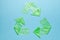 Sign recycling plastic from green bags on blue background. Environmental pollution by disposable bags, recycling