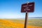 Sign reminds visitors to stay on the trail at the poppy reserve fields in California