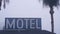 Sign of road motel or hotel, foggy misty weather California, USA. Palm trees.