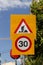 Sign `Roadworks` and sign `Speed limit` close-up