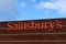 The sign of a sainsbury`s supermarket on the exterior of a store