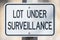 Sign saying `lot under surveillance` - close up image with great detail