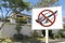 A sign saying no to open mufflers or loud exhausts near a house. Anti-noise pollution rules and regulations in a gated subdivision