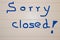 Sign saying `Sorry closed` on a light background