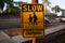 Sign says SLOW PEDESTRIAN CROSSING on the street of Los Angels, America. Street signs means the traffic rule, advertising, or many