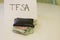 A sign that says TFSA next to a wallet that has money in it. Theme of Canadian savings. TFSA stands for tax free savings