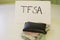 A sign that says TFSA next to a wallet that has money in it. Theme of Canadian savings. TFSA stands for tax free savings